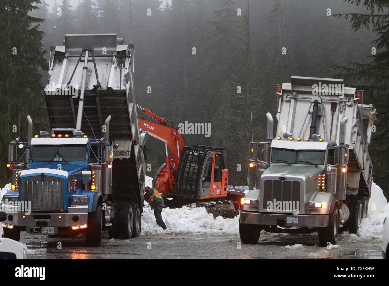Trucks haul in snow as crews continue to build the snowboard half-pipe and ski-cross courses for the 2010 Winter Olympics at the Cypress Mountain venue in West Vancouver, Canada on February 11, 2010. High temperatures and rain continues to cause problems at the Cypress Mountain venue in the lead-up to the Winter Games which begin February 12, 2010.     UPI/Brian Kersey Stock Photo