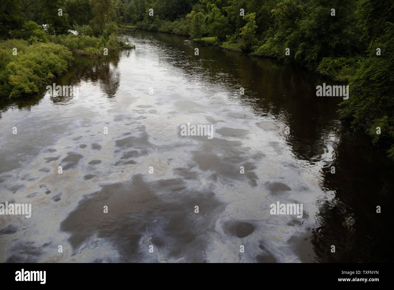 Oil flows down the Kalamazoo River near Battle Creek, Michigan on July 30, 2010. A 30-inch-diameter pipeline ruptured sometime between Sunday night and Monday morning, sending between 800,000 and 1 million gallons of oil into nearby Talmadge Creek and the Kalamazoo River.     UPI/Brian Kersey Stock Photo