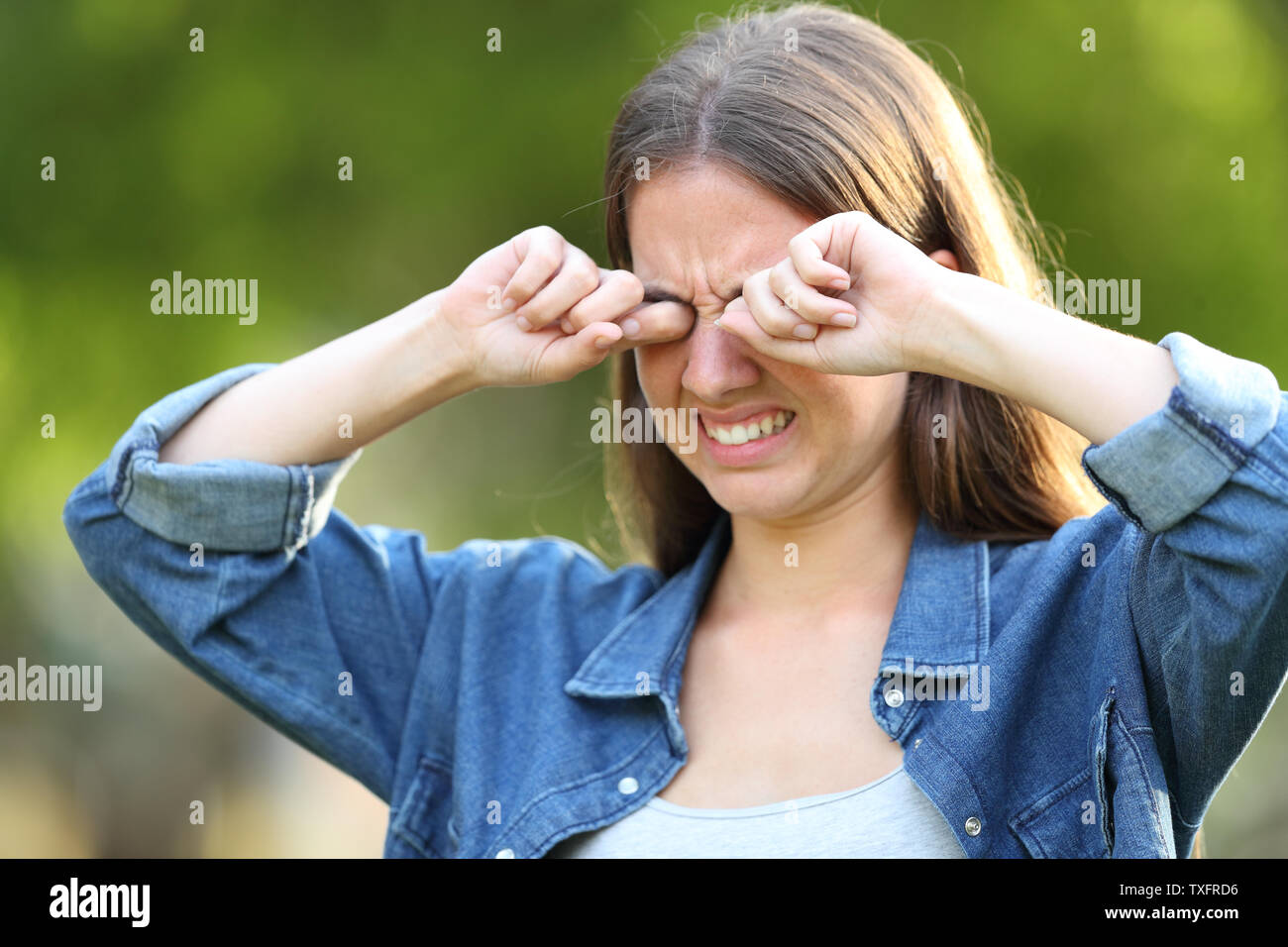 Woman suffering itching scratching eyes outdoors in a park Stock Photo