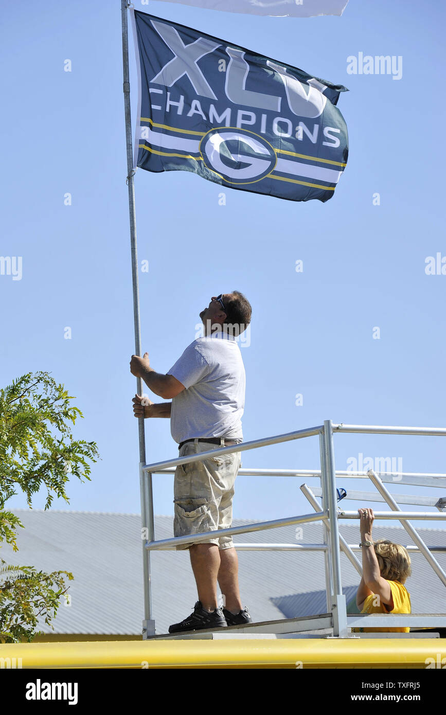 Philadelphia Eagles' Clifton Geathers holds a large American flag with a US  Air Force Airman to the left and a US Army Soldier to the right as the  National Anthem is played