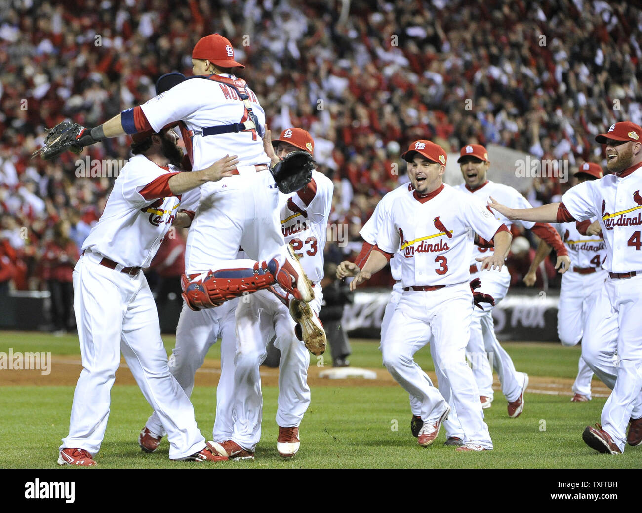St. Louis Cardinals Jason Motte (L) is jumped on by catcher Yadier Molina  as the Cardinals celebrate winning game 7 of the World Series at Busch  Stadium on October 28, 2011 in