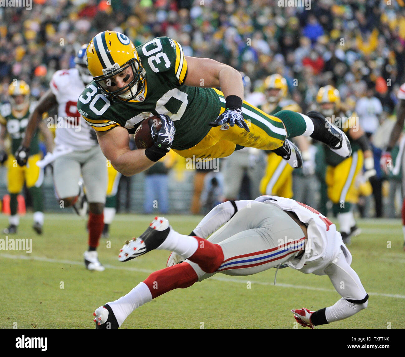 Green Bay Packers fullback John Kuhn (30) (top) is hit by New York Giants  cornerback Aaron Ross (31) as he scores a touchdown on a short pass during  the second quarter of