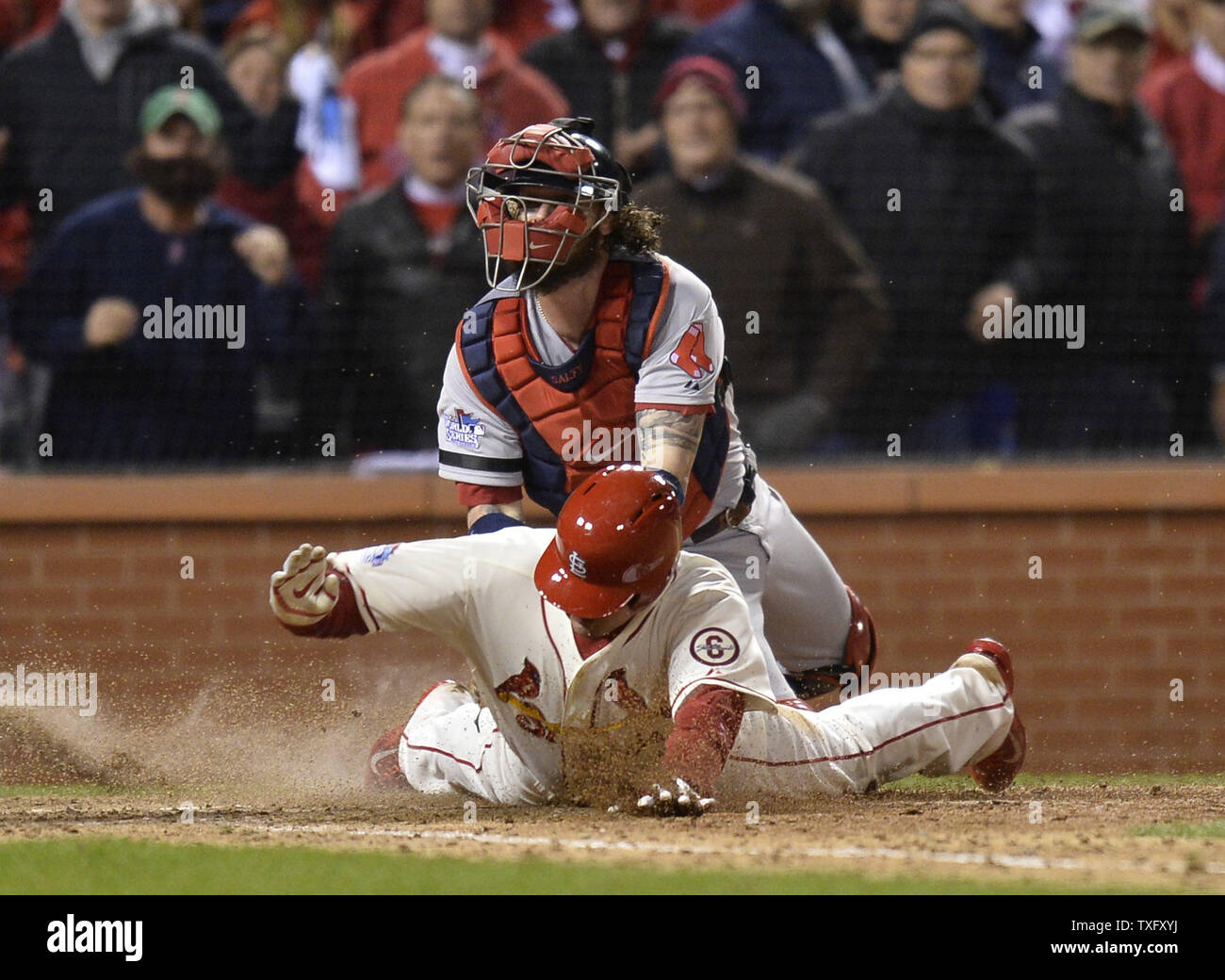 Home plate umpire Dana DeMuth (L) points to third base after Boston Red Sox  catcher Jarrod Saltalamacchia (R) tagged out St. Louis Cardinals' Allen  Craig at home plate when Craig went home