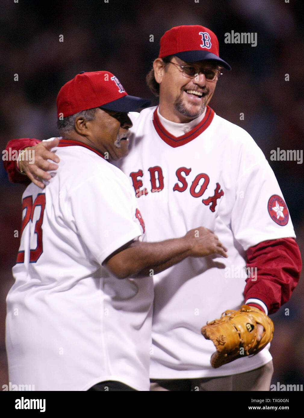 Retired pitcher Luis Tiant and Hall Fame Catcher Carlton Fisk, of the 1975 Boston Red Sox Team, embrace the pitching mount, throwing out and catching the first pitch, as