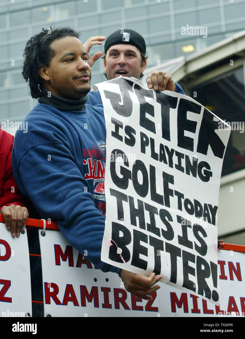 World Series MVP Manny Ramirez, of the Boston Red Sox, holds up a sigh  taunting Derek Jeter, of the New York Yankees, during the team's victory  parade through the streets of Boston