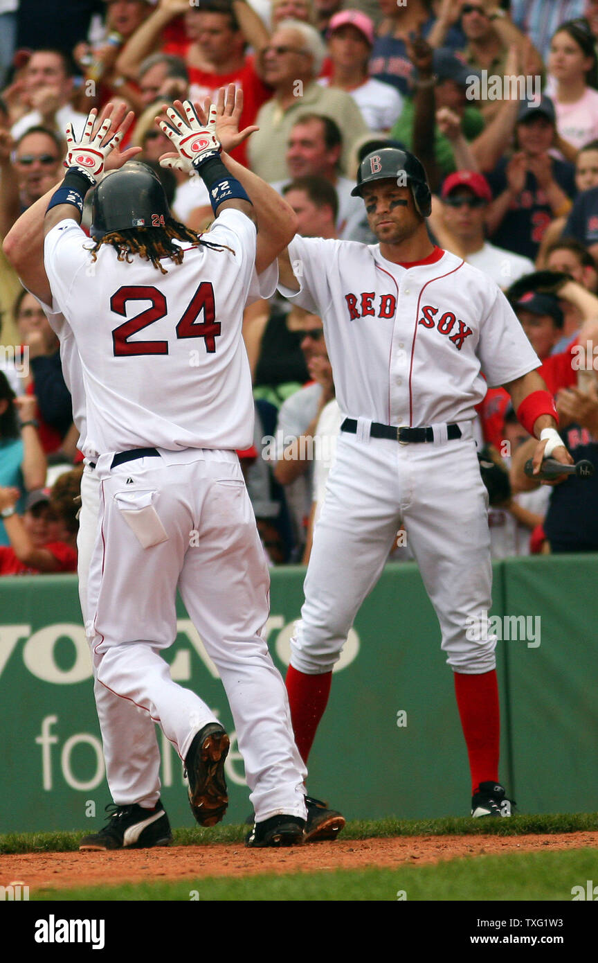 Boston Red Sox left fielder Manny Ramirez and first baseman Kevin Youkilis  celebrate after being sent home by designated hitter Wily Mo Pena during  the third inning against the Texas Rangers at