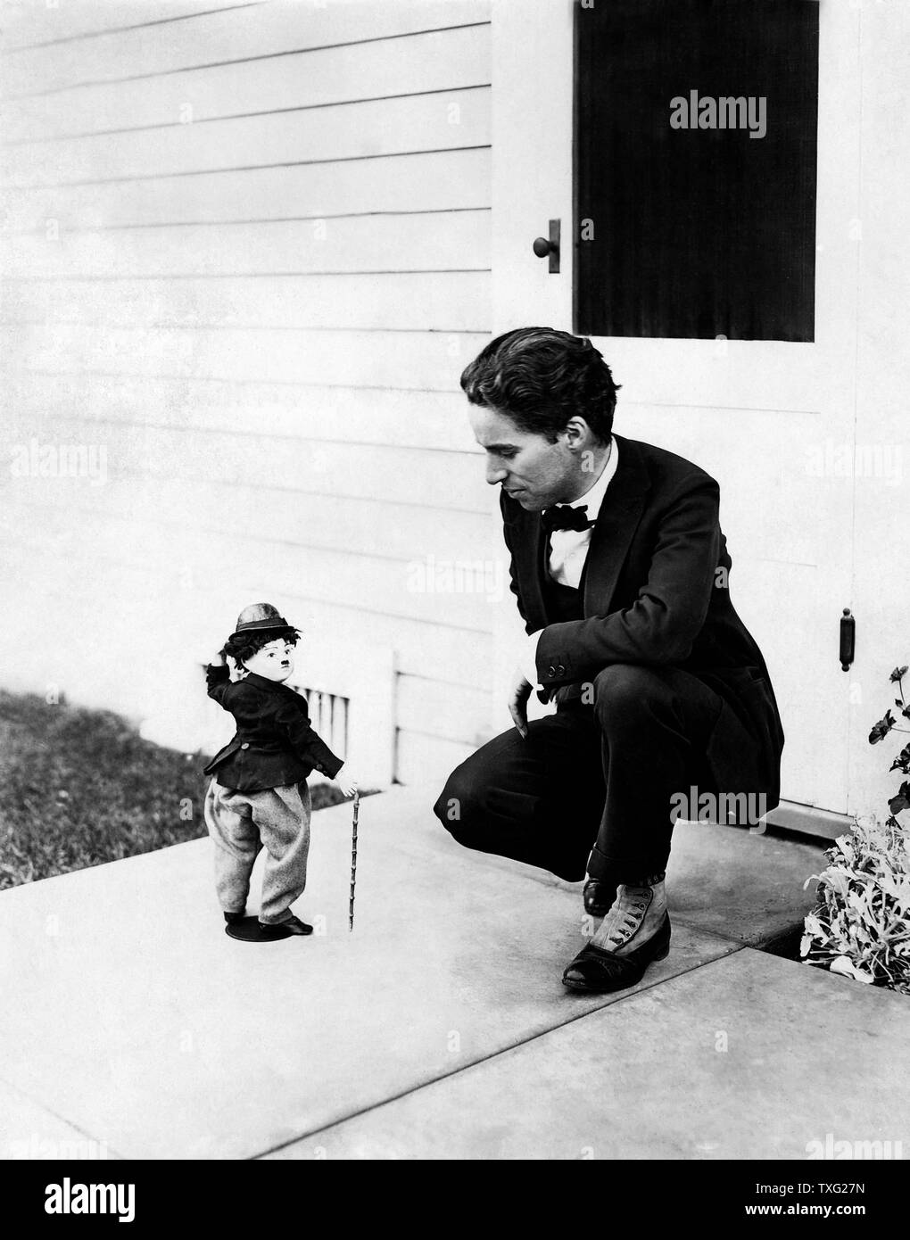 Director, actor, producer Charles Chaplin with a figurine in his image Ca 1915 Stock Photo