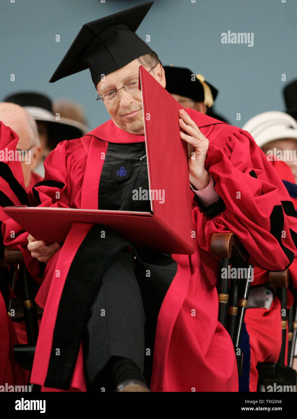 Microsoft chairman, Bill Gates, looks over his honorary degree from