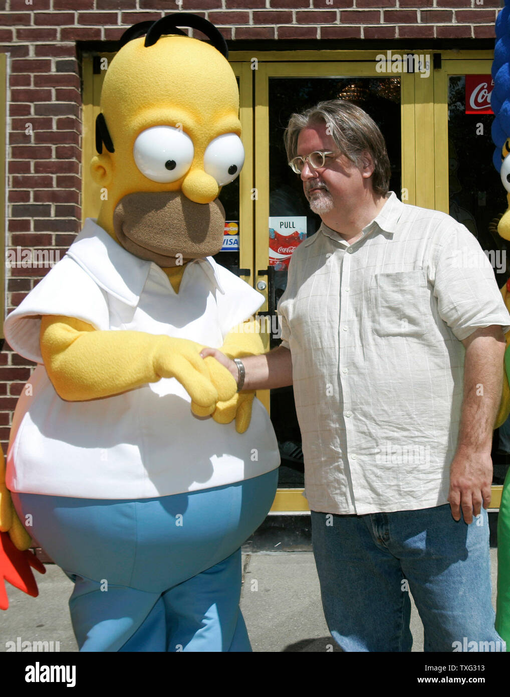 'The Simpsons Movie' producer Matt Groening (R) shakes hands with Homer Simpson at the hometown premier of The Simpsons Movie at the Springfield Movie Theater in Springfield, Vermont on July 21, 2007.  (UPI Photo/Matthew Healey) Stock Photo