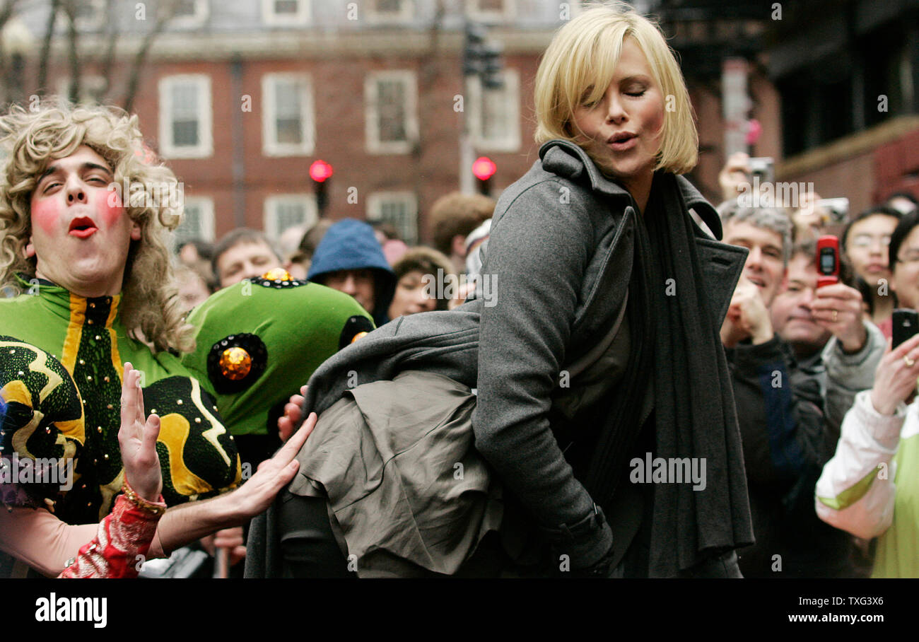 Actress Charlize Theron (R) receives from a Harvard University student