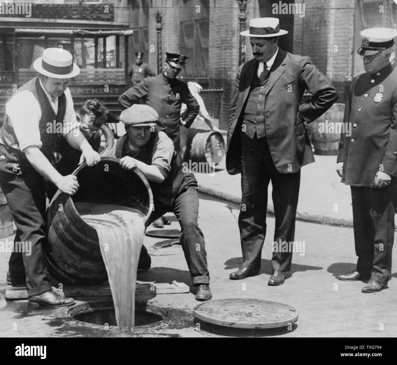 Prohibition in the USA 1920-1933 : A barrel of confiscated illegal beer being poured down a drain Stock Photo