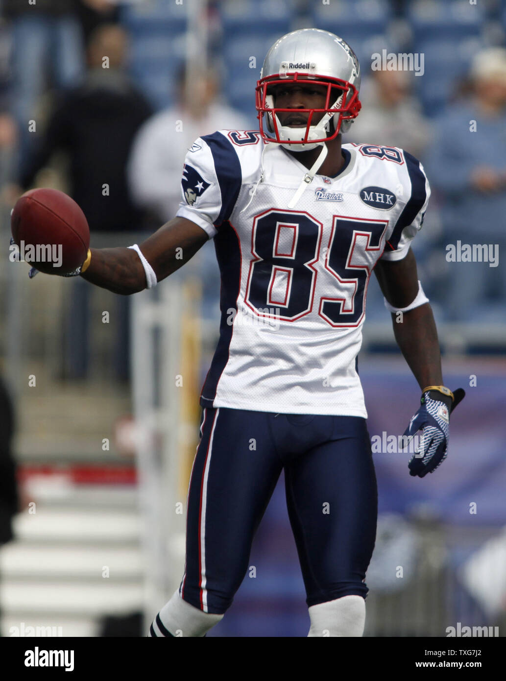 New England Patriots wide receiver Chad Ochocinco grabs a football while  warming up with teammates before the game against the Dallas Cowboys at  Gillette Stadium in Foxboro, Massachusetts on October 16, 2011.