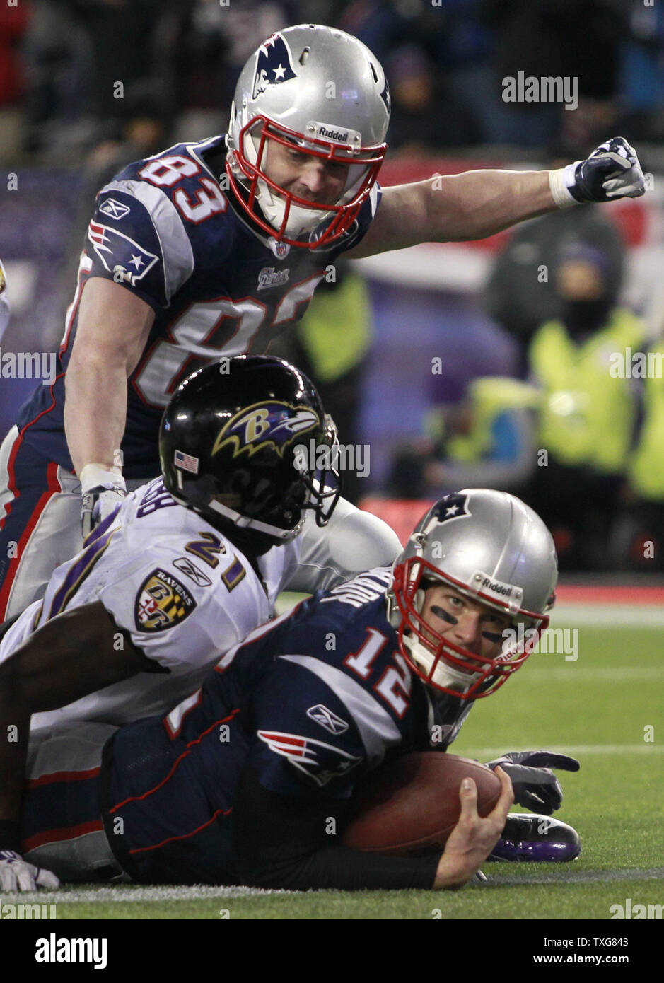 New England Patriots quarterback Tom Brady (12) looks up after being stopped by Baltimore Ravens cornerback Lardarius Webb (21) as Patriots Wes Welker pumps his fist (83) on a small gain on a quarterback sneak in the AFC Championship game at Gillette Stadium in Foxboro, Massachusetts on January 22, 2012.  The Patriots defeated the Ravens 23-20.  UPI/Matthew Healey Stock Photo
