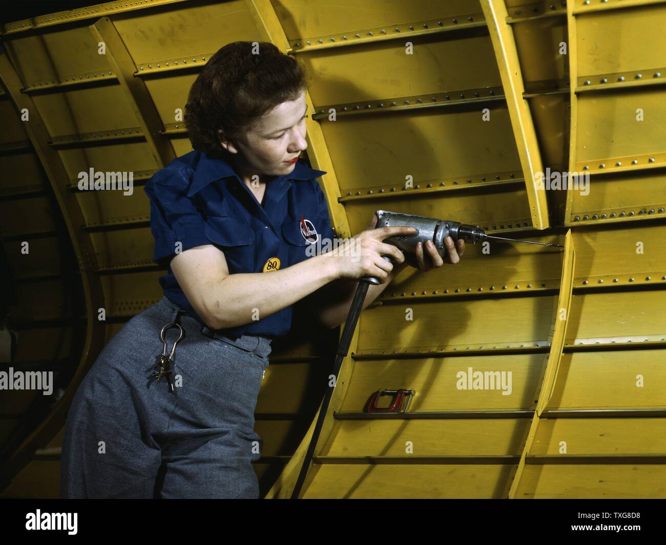 Female aviation worker using a rivet gun on the interior of a USAF aircraft during World War II Stock Photo