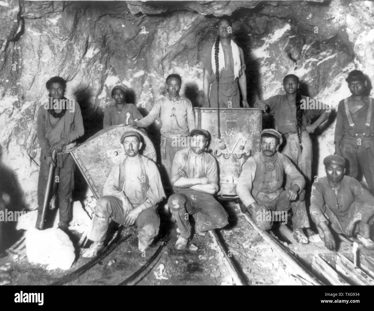 Black, Chinese, and White labourers in a gold mine in South Africa Stock Photo