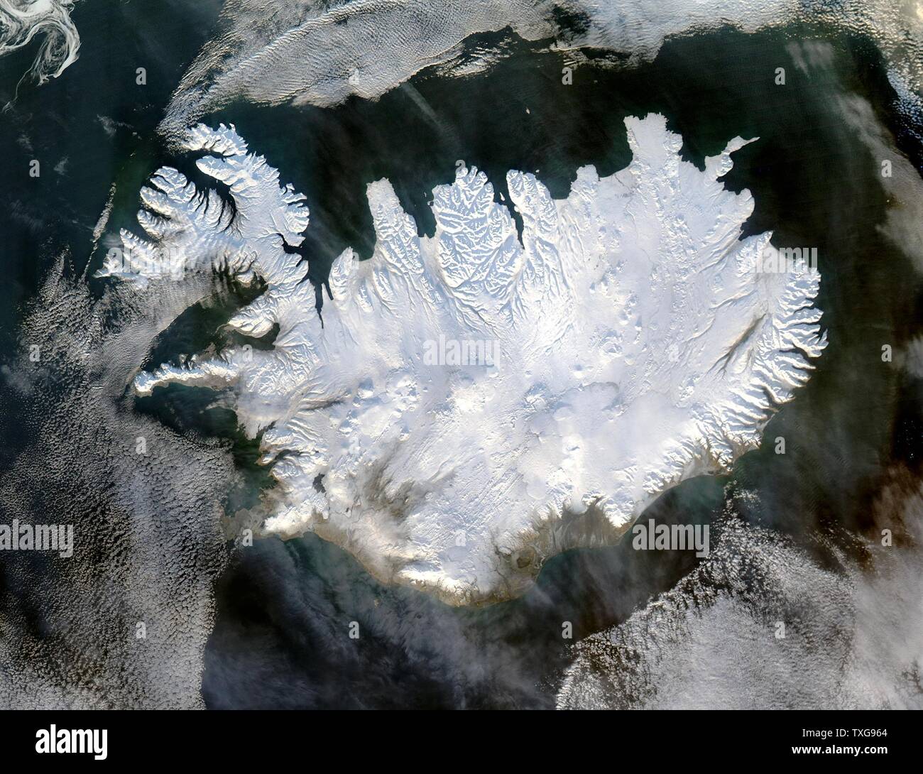 Satellite image of Iceland on 28  January 2004 showing it covered in a blanket of snow and ice which is obscuring the permanent glaciers and icecaps that exist year-round. Credit NASA Stock Photo