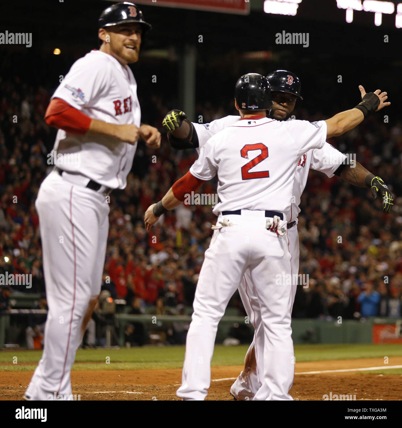 Boston Red Sox designated hitter David Ortiz (R) is hugged by teammate Jacoby  Ellsbury (2) as Will Middlebrooks cheers (L) after Ortiz connected for a  grand slam in the eighth inning of