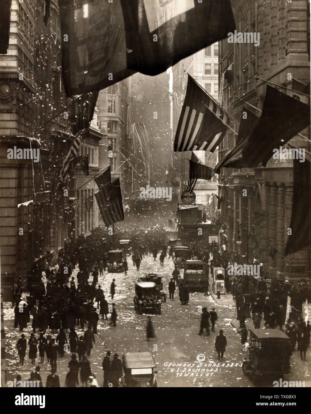Germany surrenders. Photograph shows celebrations on Wall Street with confetti, American flags, and crowds of people. Stock Photo
