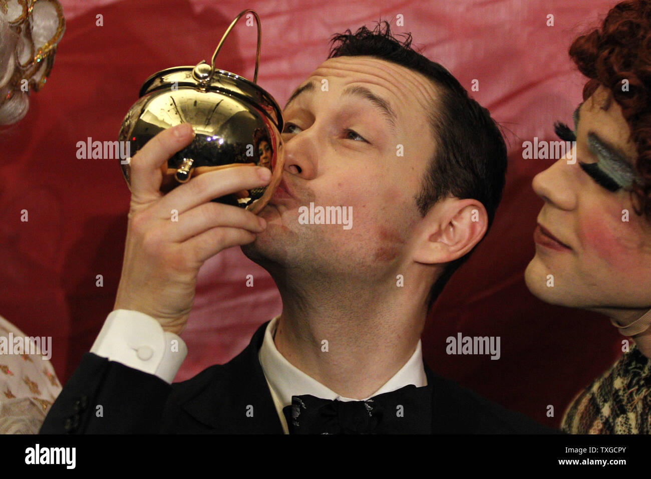 Actor Joseph GordonLevitt (L) kisses his pudding pot trophy while