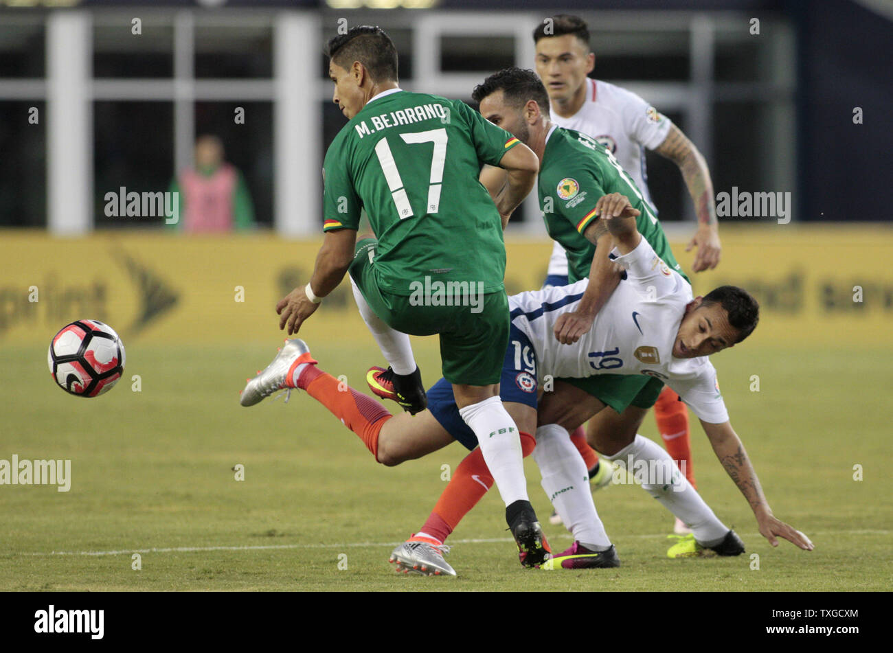 Chile forward Fabian Orellana (19) tangles with Bolivia forward Alejandro Melean (13) as Bolivia Mdefender Marvin Bejarno (17) chases after the ball in the second half of the Copa America Centenario Group D match at Gillette Stadium in Foxboro, Massachusetts on on June 10, 2016. Chile defeated Bolivia 2-1.  Photo by Matthew Healey/UPI Stock Photo
