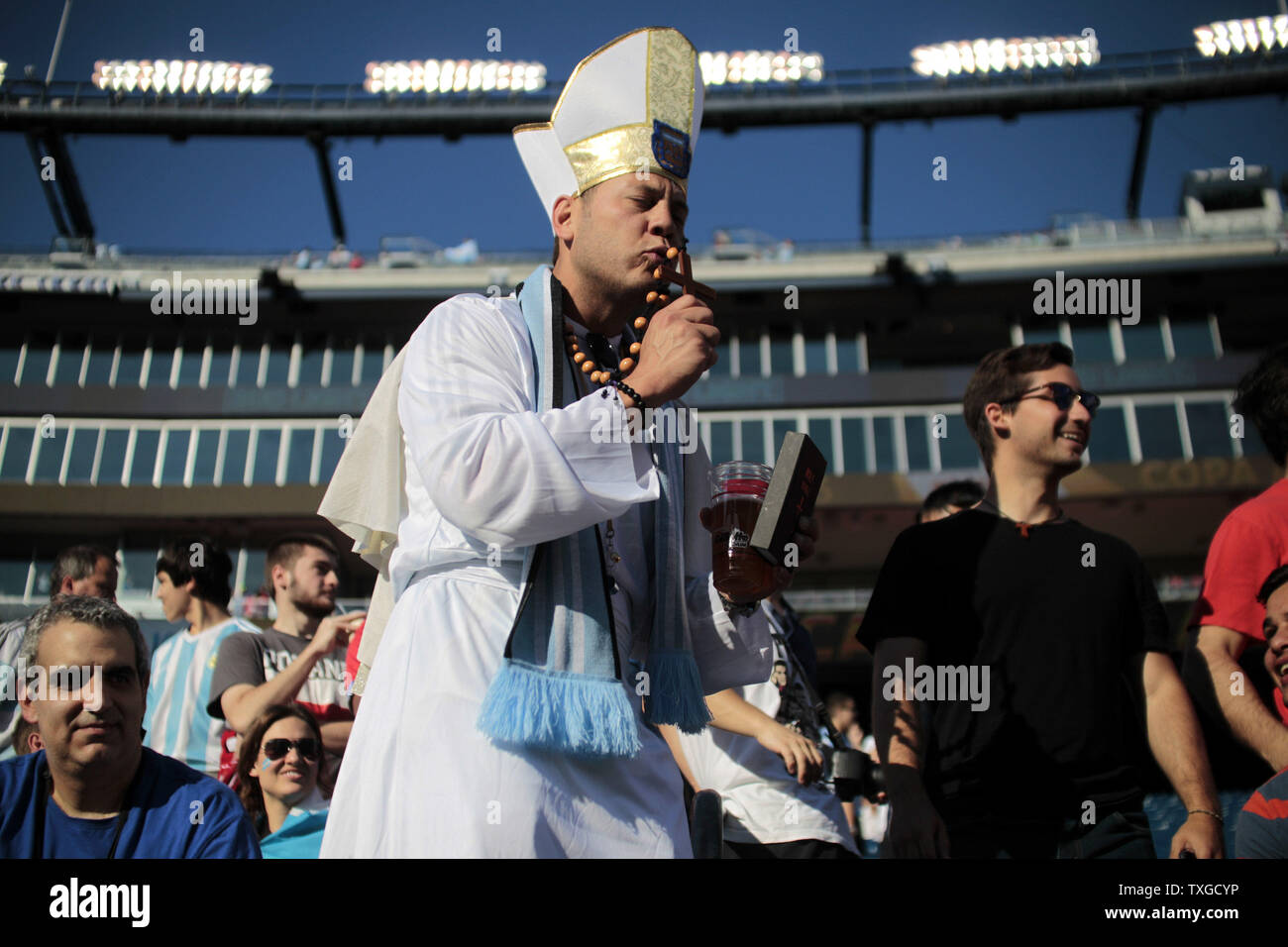 An Argentina fan dressed as the Pope kisses a crucifix prior to the 2016 Copa America Centenario quarterfinal match between Argentina and Venezuela at Gillette Stadium in Foxborough, Massachusetts on June 18, 2016.  Photo by Matthew Healey/UPI Stock Photo