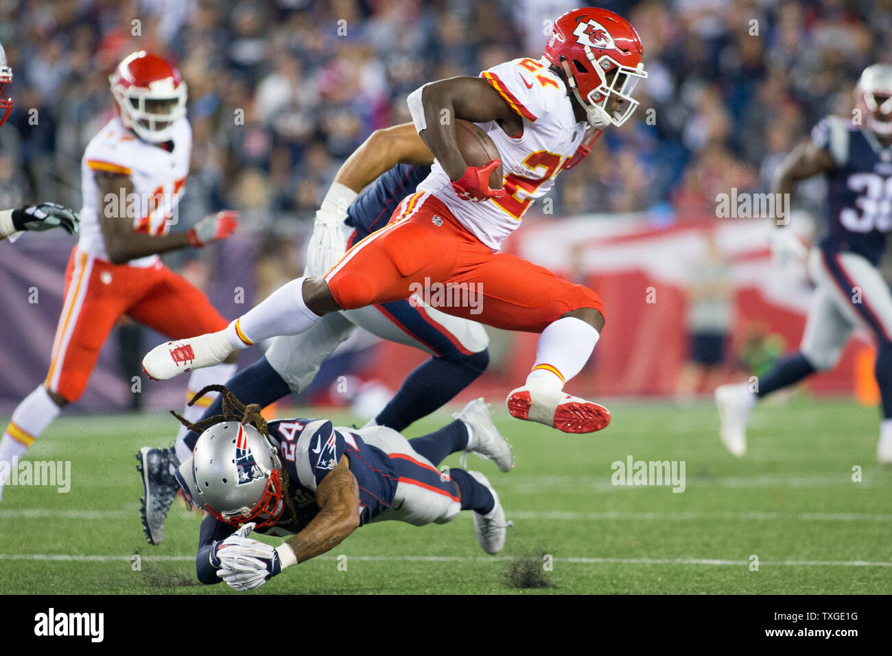 Kansas City Chiefs running back Kareem Hunt (27) dodges a tackle by New  England Patriots cornerback Stephon Gilmore (24) on a carry in the fourth  quarter at Gillette Stadium in Foxborough, Massachusetts