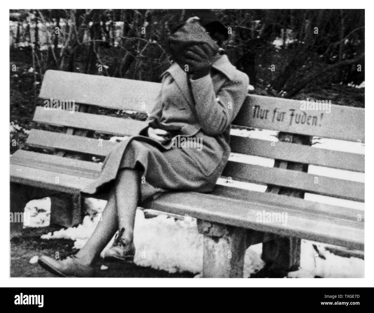 Photograph of a Jewish woman in Austria sitting on a bench marked “Only for Jews.” Dated 1938 Stock Photo