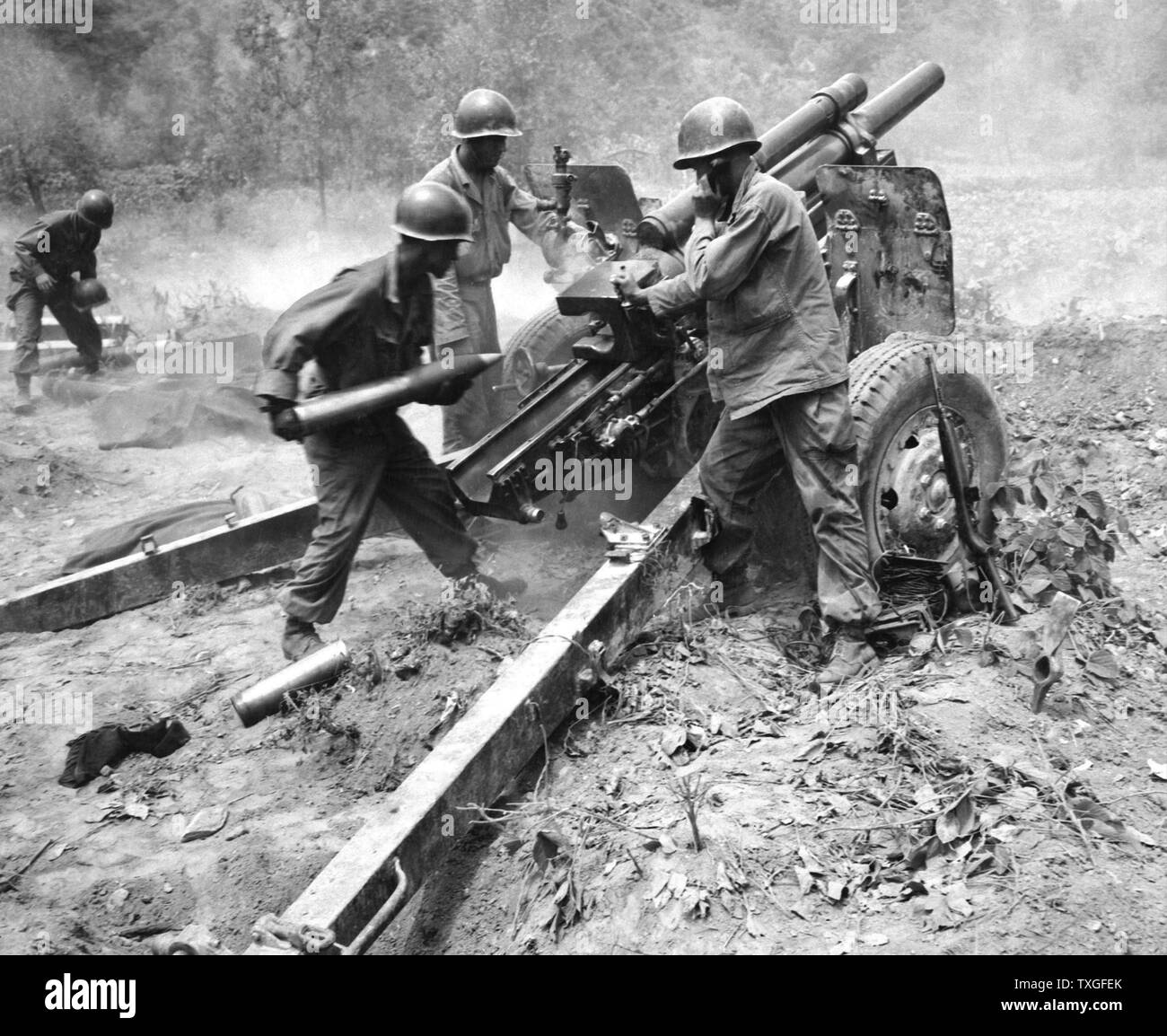 US Army artillery crew firing a 105 millimetre howitzer, against North Korean positions during the Korean War 1950 Stock Photo