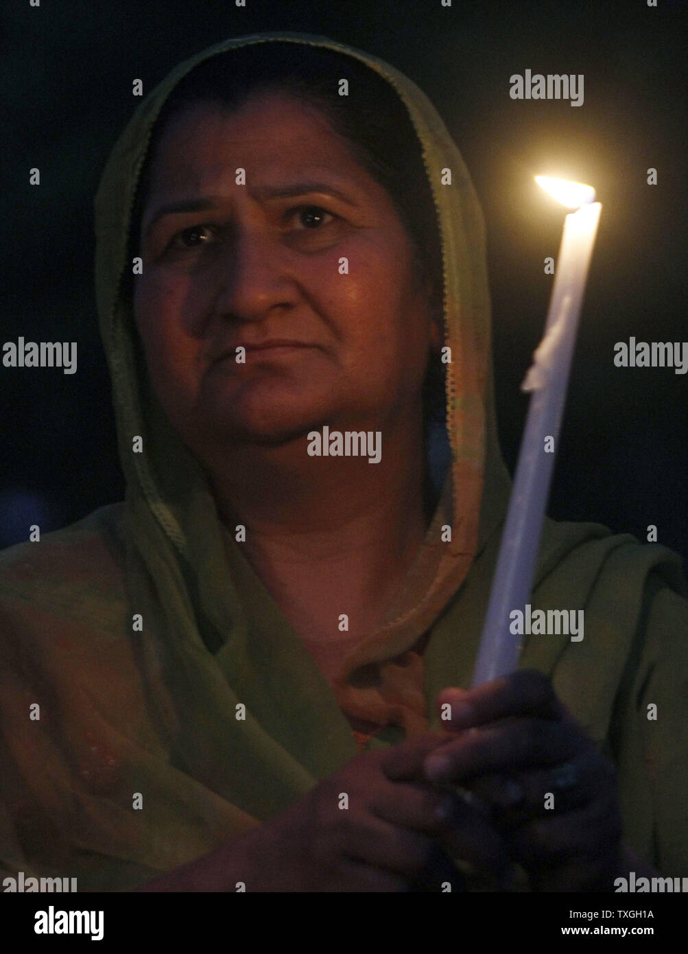 A memeber of the Sikh community pauses during a candlelight vigil August 6, 2012 in Brookfield, Wisconsin. Police have identified Wade Michael Page as their suspect in the shooting. Page, a former Army veteran, was killing in a shootout with police. UPI/Frank Polich Stock Photo