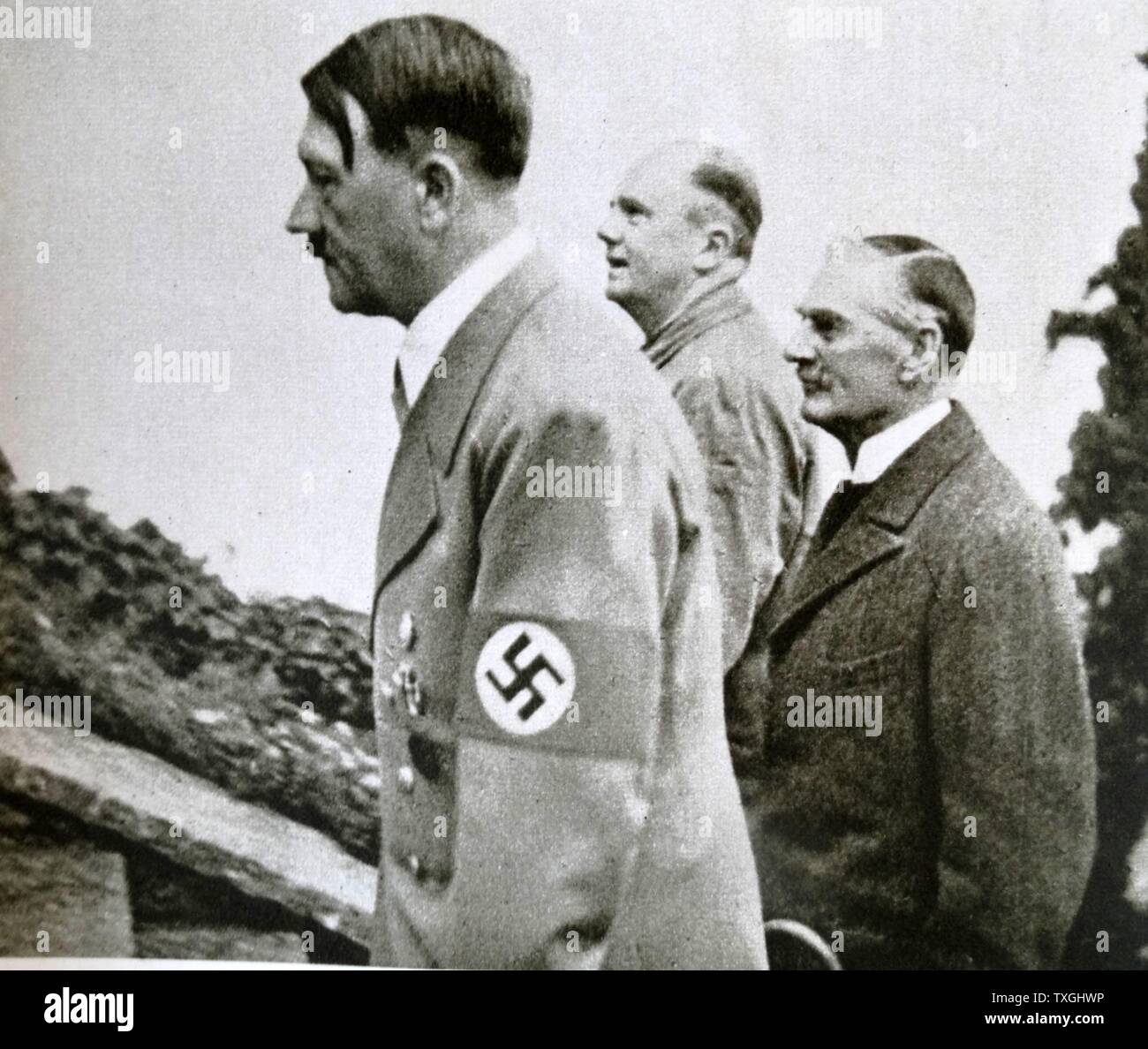 Photographic print of Adolf Hitler (1889-1945) a German politician who was the leader of the Nazi Party, Chancellor of Germany, and Führer of Nazi Germany, Joachim von Ribbentrop (1893-1946) a Foreign Minister of Nazi Germany, and Neville Chamberlain (1869-1940) a British Conservative politician and Prime Minister of the United Kingdom. Dated 20th Century Stock Photo