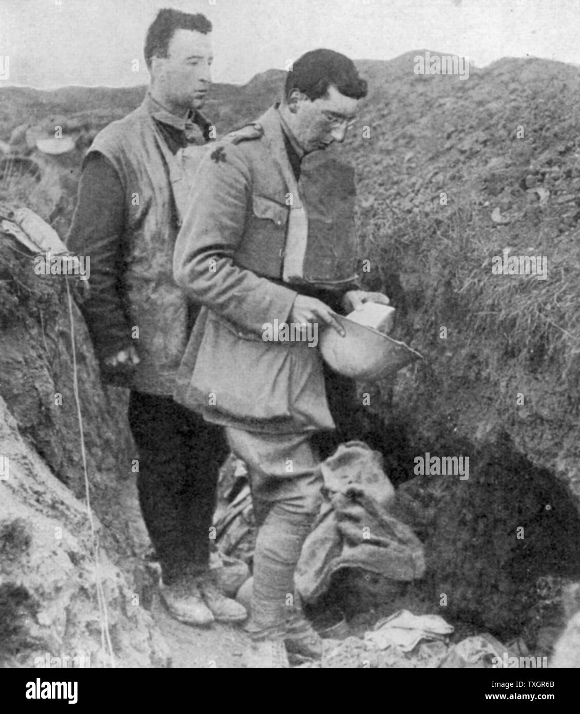 World War I: Chaplain of the lst Munsters saying a burial prayer over soldiers killed in their trench by a German shell October 1918   Near Cambrai Stock Photo