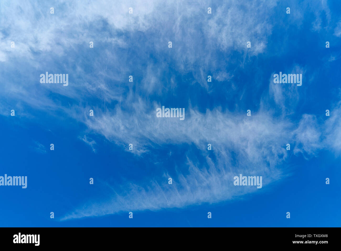 White clouds in the blue sky. Atmospheric phenomenon. Stock Photo