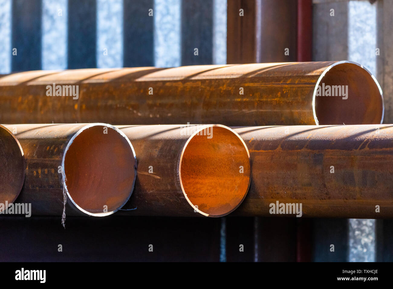Stack of cylindrical round steel pipes. Industrial theme Stock Photo