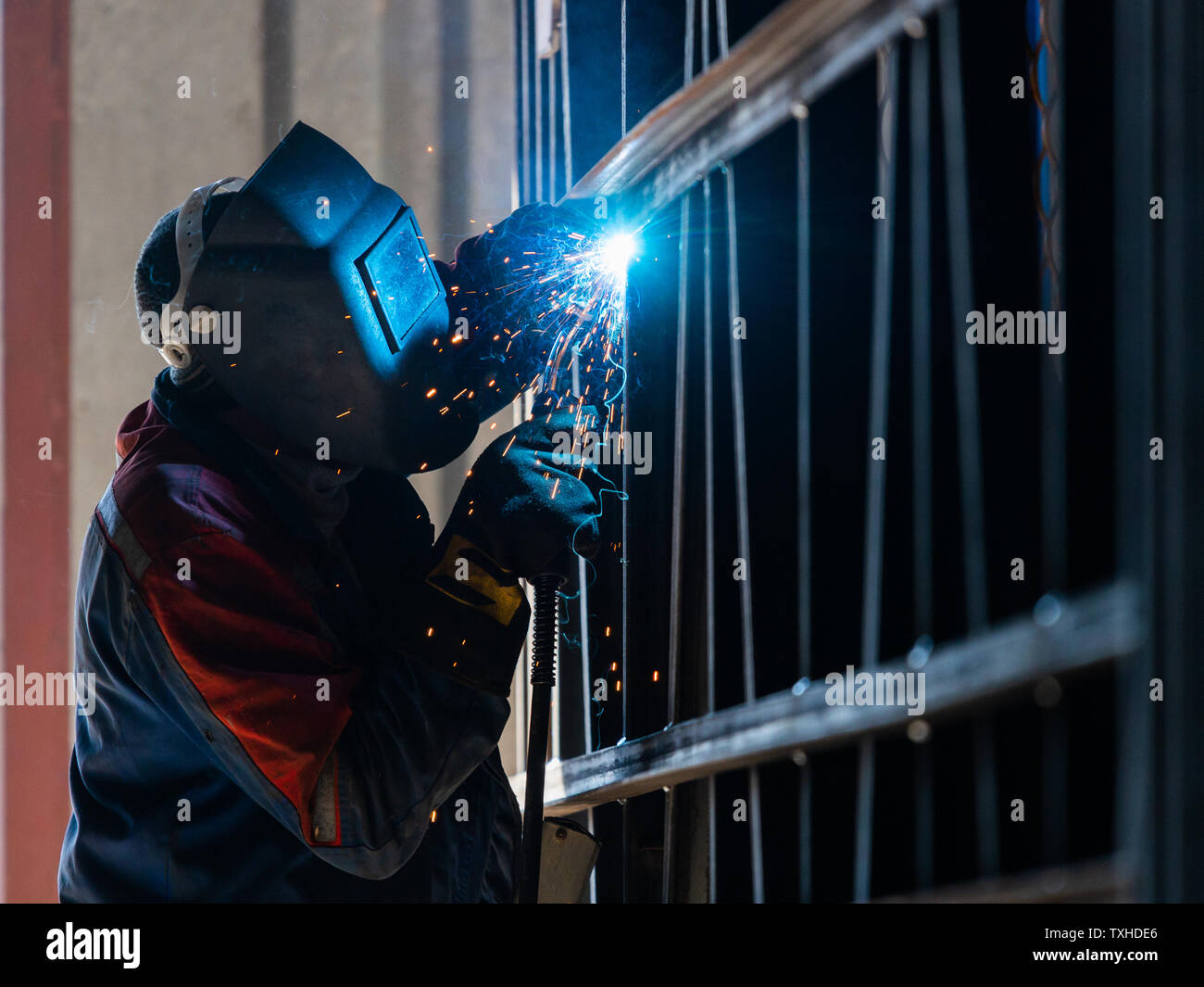 Industrial Worker labourer at the factory arc welding steel structure. Stock Photo
