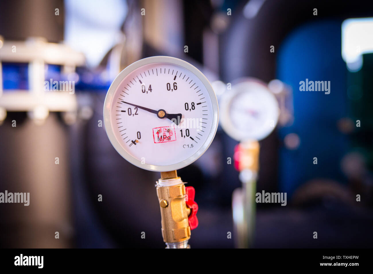 Closeup of manometer, measuring gas pressure. Pipes and valves at