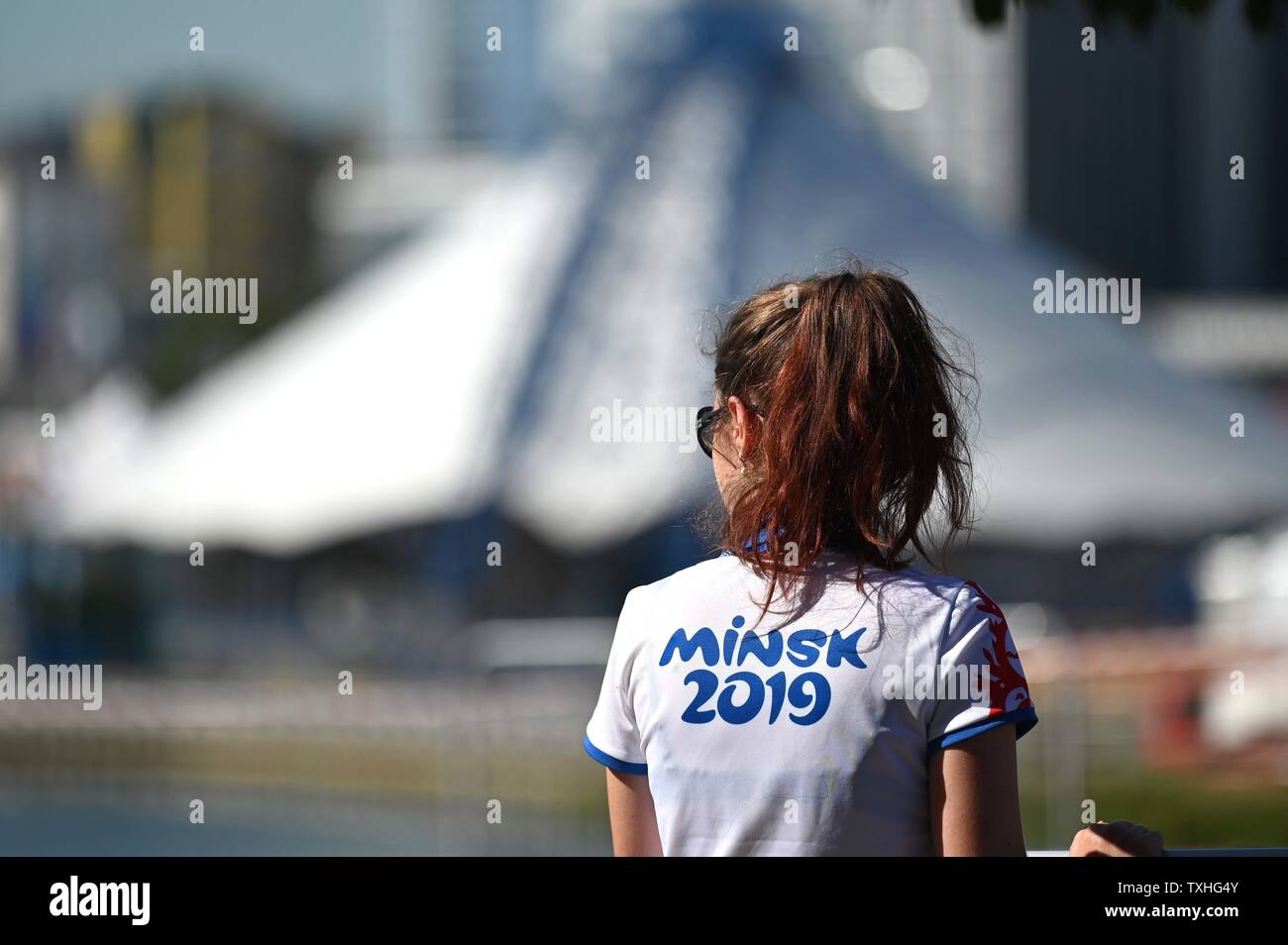 Minsk. Belarus. 25 June 2019. A volunteer waits for the cycling time trial at the 2nd European games to begin, with the city in the background. Credit: Sport In Pictures/Alamy Live News Stock Photo