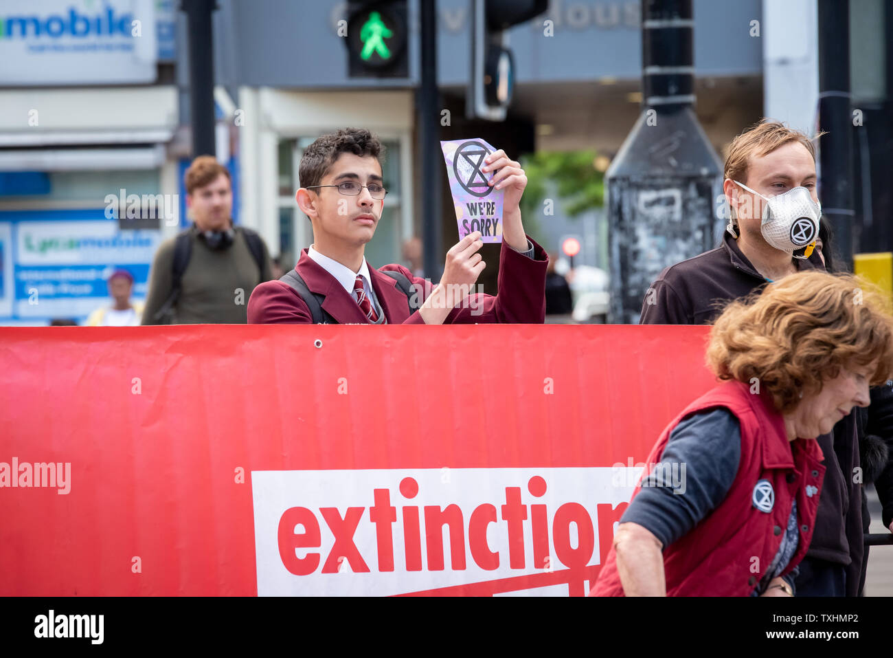 Young man in school uniform stops traffic in Catford, London for Extinction Rebellion Stock Photo