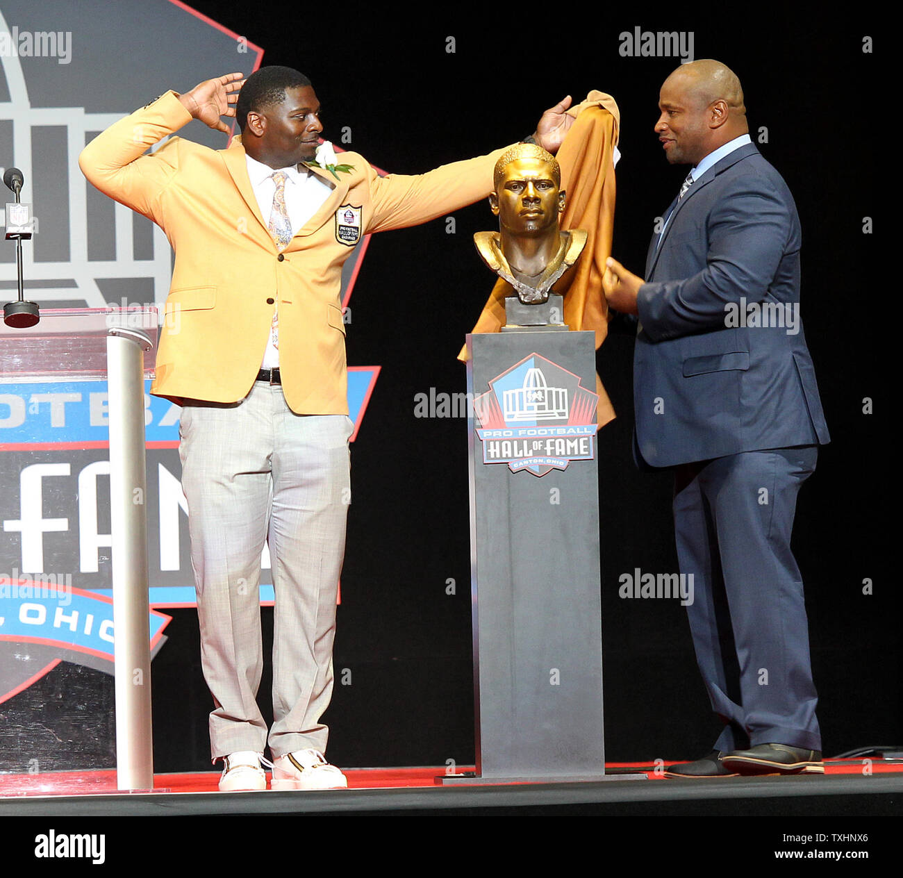 LaDainian Tomlinson, with the help of Lorenzo Neal, uncovers his bust during his enshrinement into the Pro Football Hall of Fame at Tom Benson Hall of Fame Stadium in Canton, Ohio on August 5, 2017.     Photo by Aaron Josefczyk/UPI Stock Photo