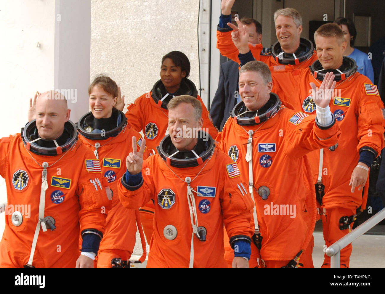 Commander Steven Lindsey (R) gives the victory sign as he walks out with Pilot Mark Kelly (L) and Mission Specialists  Lisa Nowak (2nd Row,L), Michael Fossum (2nd row,R), Stephanie Wilson (3rd Row,L), Piers Sellers(3rd Row,R), and Thomas Reiter (rear) of Germany, from the Operations and Checkout Building to board the NASA Astrovan en route to the Space Shuttle Discovery for mission STS-121 at Cape Canaveral, Florida on July 2, 2006.  (UPI Photo/Pat Benic) Stock Photo