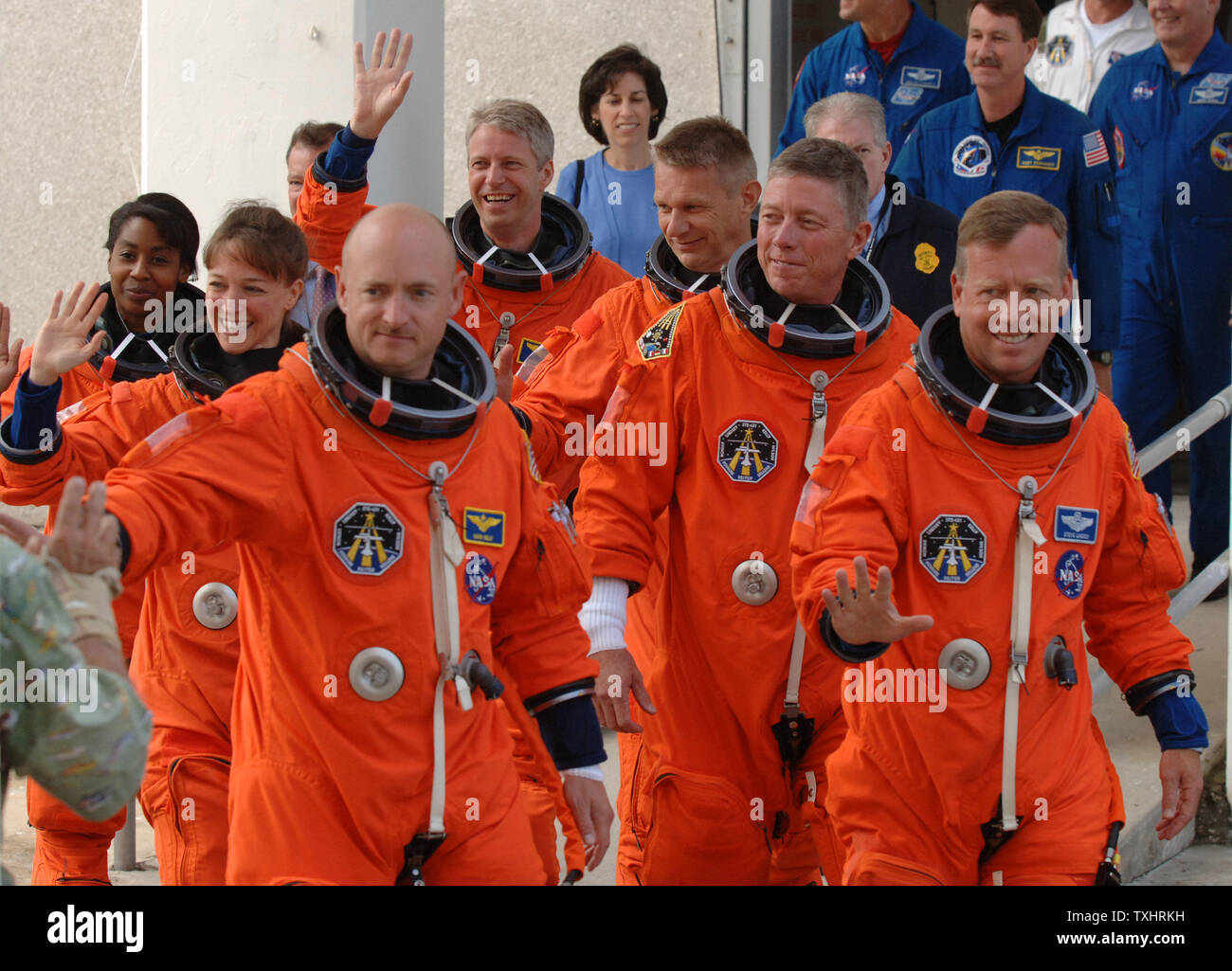 Commander Steven Lindsey (R),Pilot Mark Kelly (L,front) and Mission Specialists  Lisa Nowak (2nd Row,L), Michael Fossum (2nd row,R), Stephanie Wilson (3rd Row,L), Piers Sellers(3rd Row,R), and Thomas Reiter (rear) of Germany, wave to spectators as they walk from the Operations and Checkout Building to board the NASA Astrovan en route to the Space Shuttle Discovery for mission STS-121 at Cape Canaveral, Florida on July 2, 2006.  (UPI Photo/Pat Benic) Stock Photo