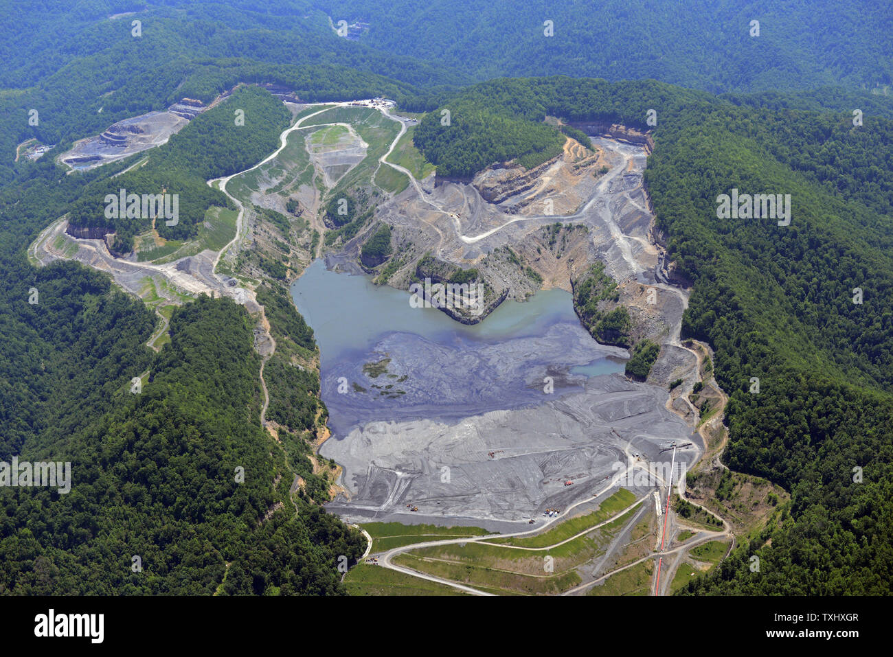 An aerial photo shows a mountaintop removal site and sludge pond in