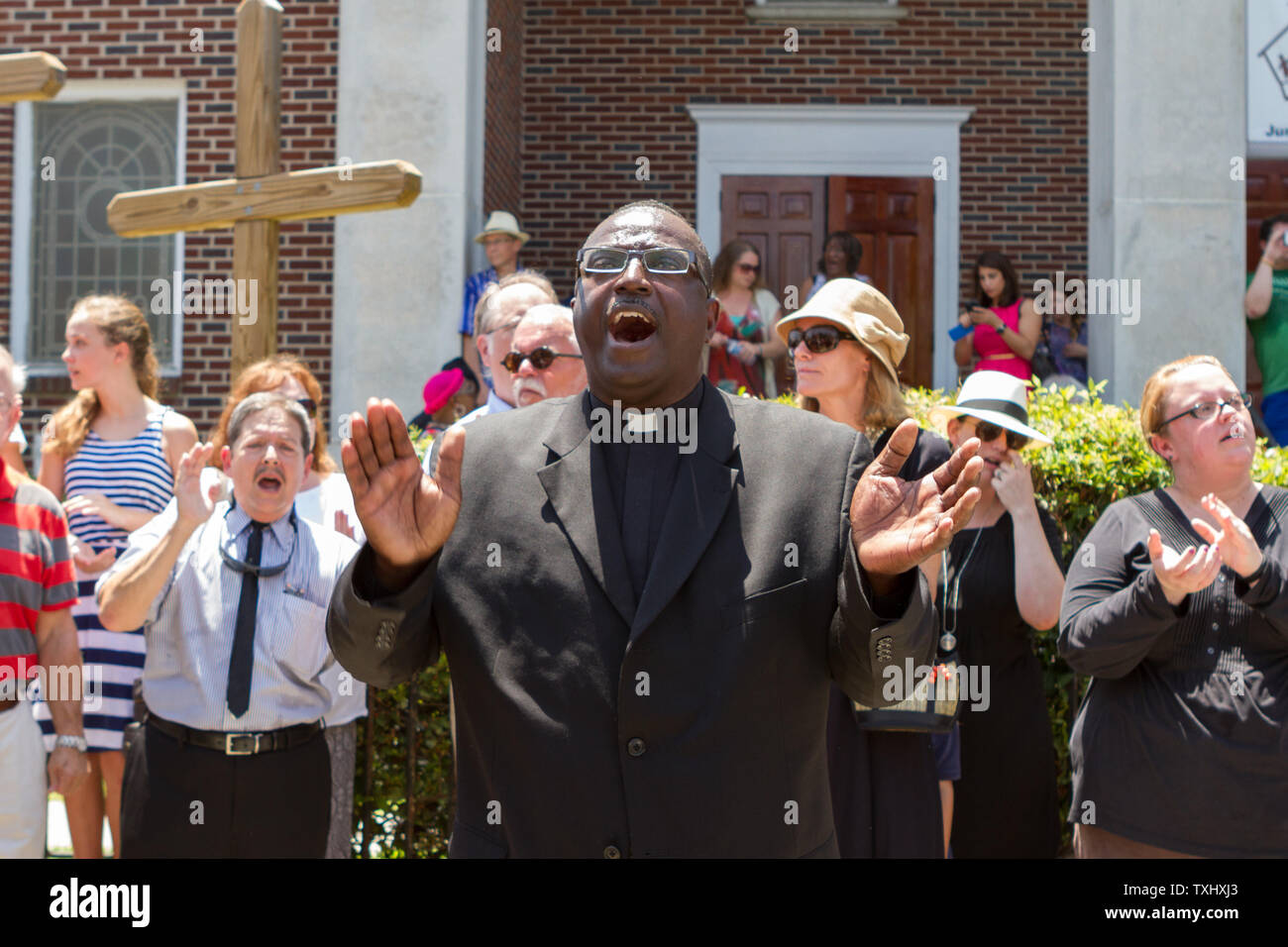 HA local minister leads a crowd in hymns during a prayer vigil outside the Morris Brown AME church in Charleston, South Carolina on June 18, 2015. The vigil attended by hundreds was in honor of the nine people killed by a lone gunman at the Mother Emanuel African Methodist Episcopal Church on June 17, 2015.  The  suspect was captured.  Photo by Gillian Ellis/UPI Stock Photo