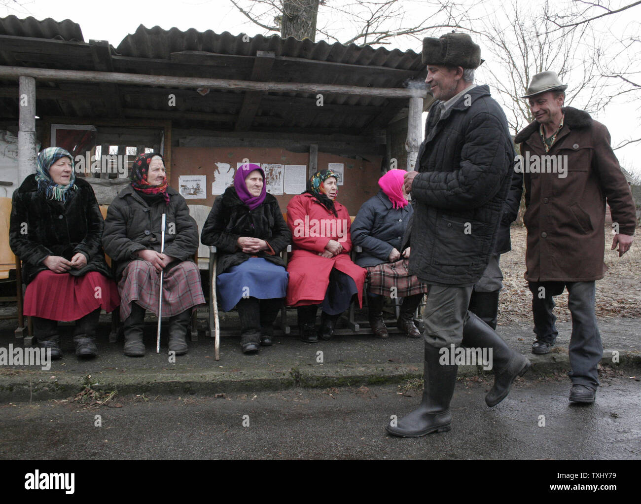 Elderly Ukrainian illegal settlers in the exclusion zone around the closed Chernobyl nuclear power plant wait for open air concert in the Ilinci village, April 5, 2006. Ukraine will mark at the end of April the 20th anniversary of the Chernobyl nuclear disaster, when the fourth reactor at the Chernobyl plant exploded, spreading a radioactive cloud across the former Soviet Union. Thousands of people died from the effects of the radiation and millions more in the region and across Europe have suffered health problems. (UPI Photo/Sergey Starostenko) Stock Photo