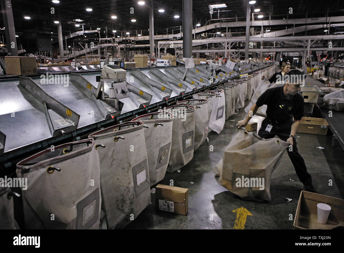 Victor Moreno, right, sorts packages at UPS' Chicago Area Consolidation Hub in Hodgkins, Illinois on December 15, 2006. UPS' Hodgkins location, which is the world's largest package sorting and distribution facility in terms of size and package volume, expects to handle 2 million packages Friday. (UPI Photo/Brian Kersey) Stock Photo