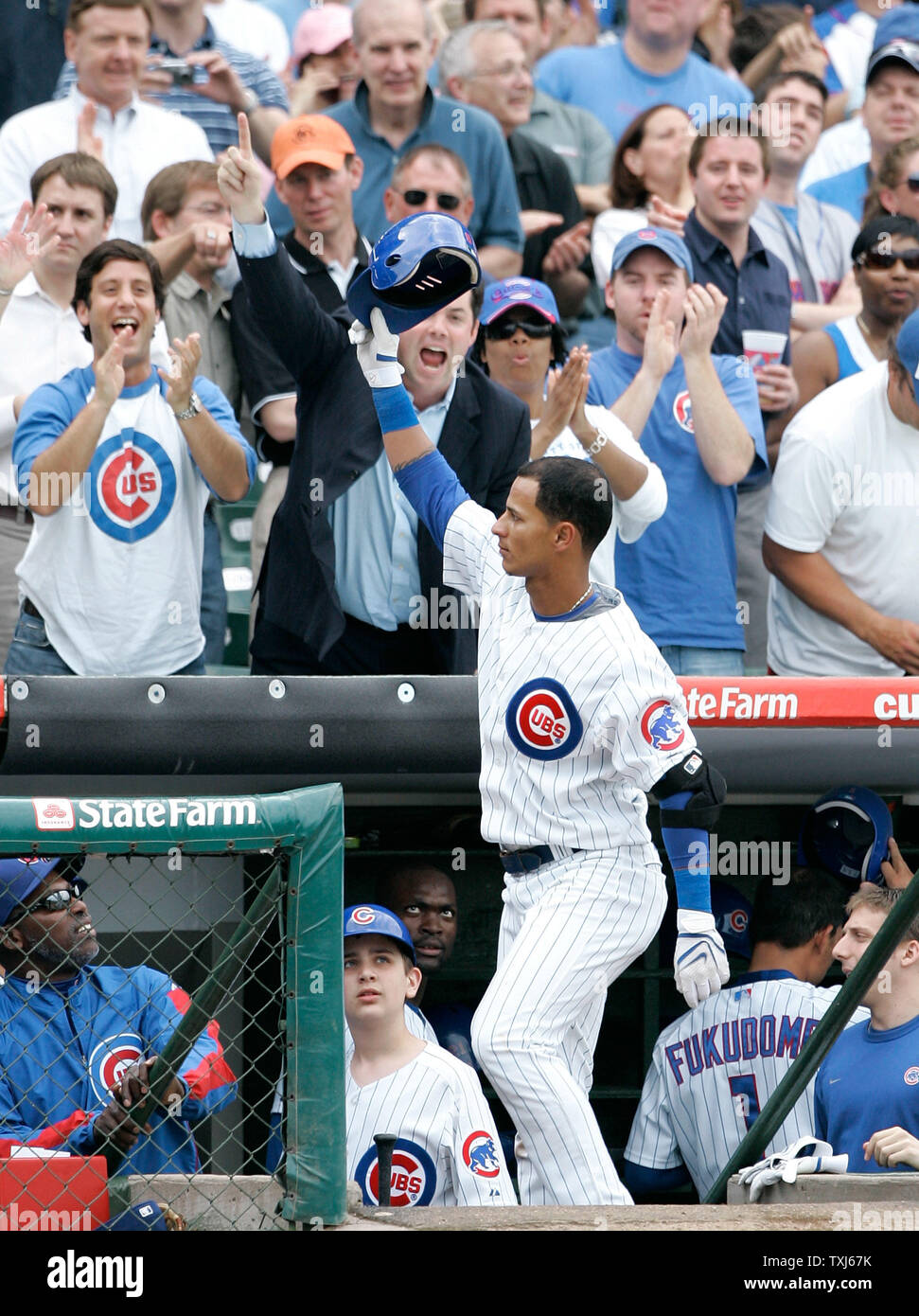 Chicago Cubs' Ronny Cedeno tips his cap to the crowd after hitting