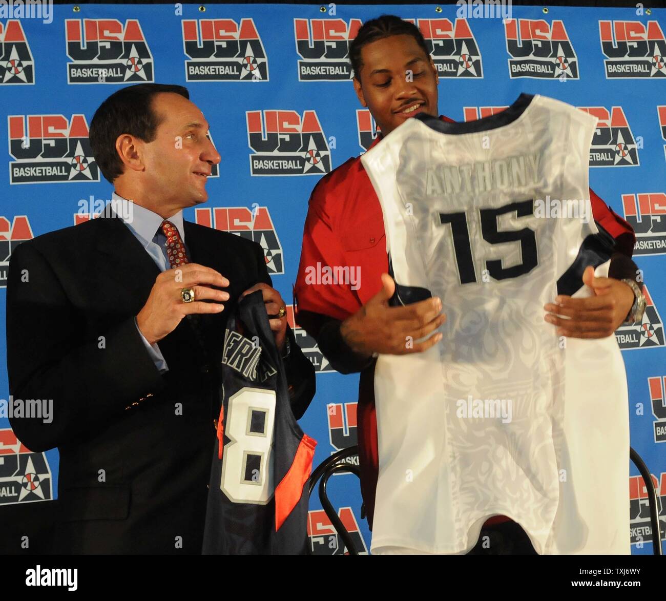 USA Basketball head coach Mike Krzyzewski (L) and team member Carmelo  Anthony (R) look at the jerseys after the announcement of the 12 players  selected for the USA Basketball Men's Senior National