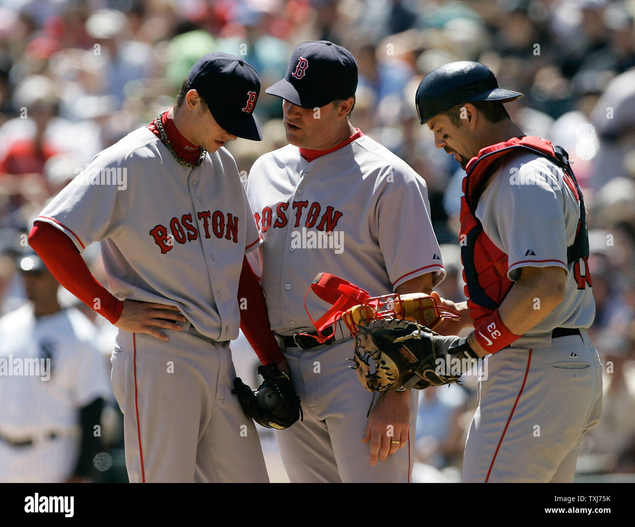 Boston Red Sox pitching coach John Farrell (C) and catcher Jason