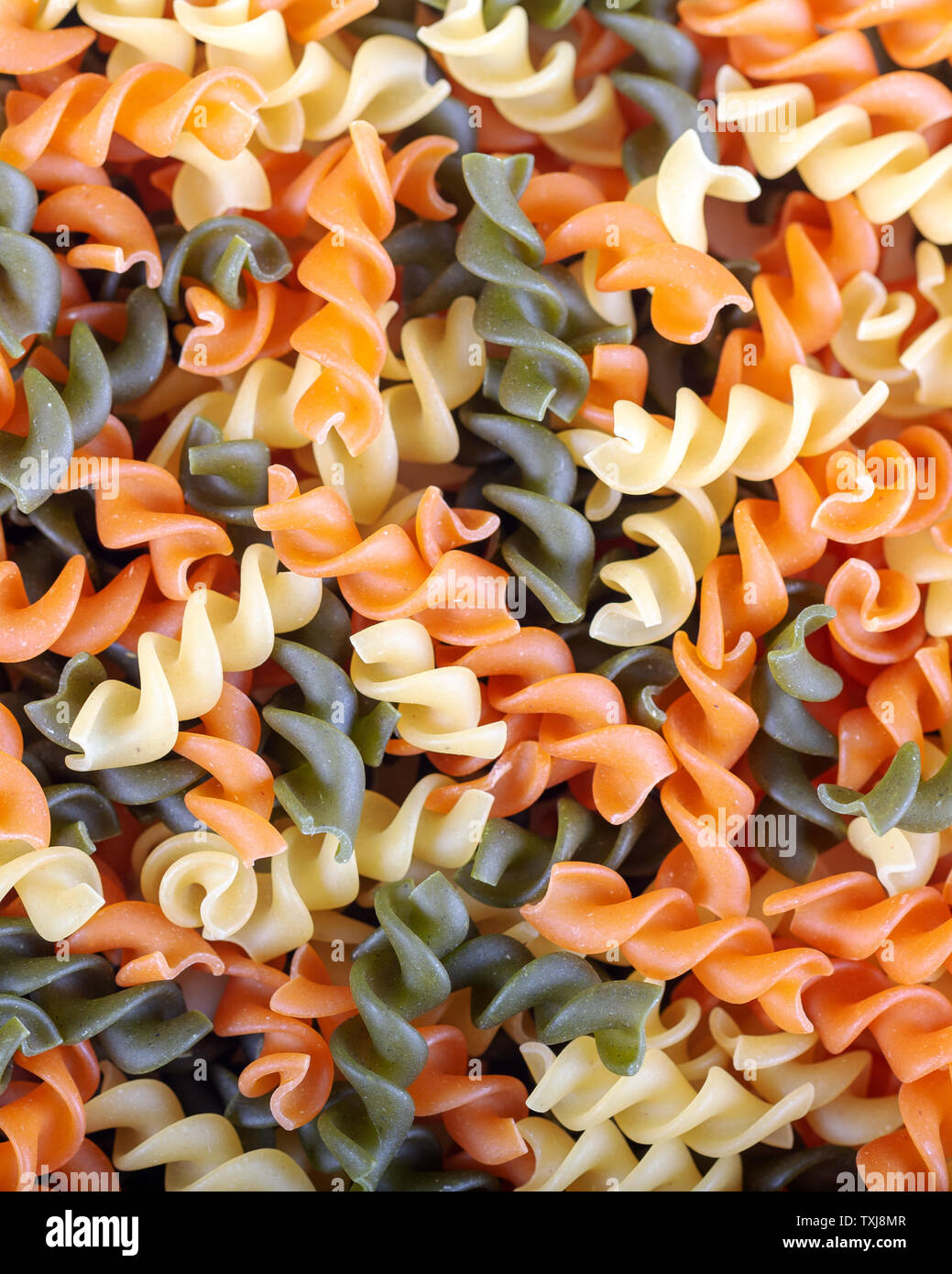 Colorful raw rutini pasta with vegetables like as background. Stock Photo