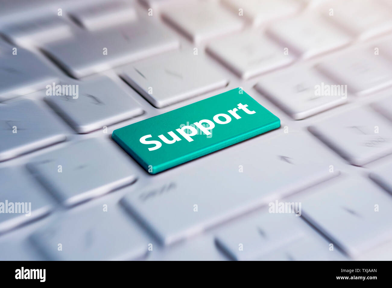 Blue support keyboard button. Green Button on grey Computer Keyboard. blurred in motion background. Stock Photo