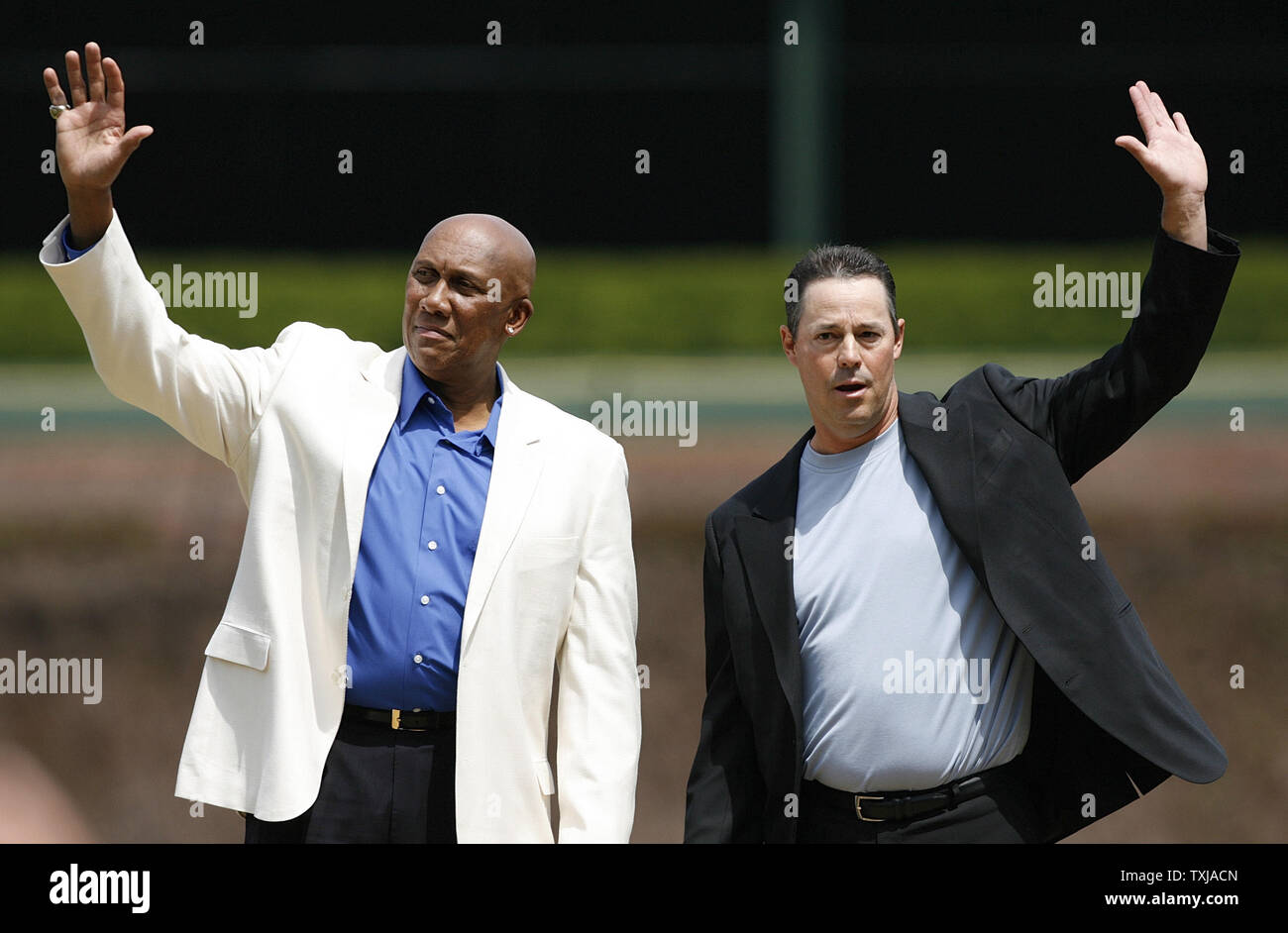 Former Chicago Cubs pitchers Ferguson Jenkins (L) and Greg Maddux wave to the crowd after their